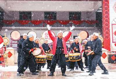 　　山西洪洞威风锣鼓研究协会队员们正在雪中排练。